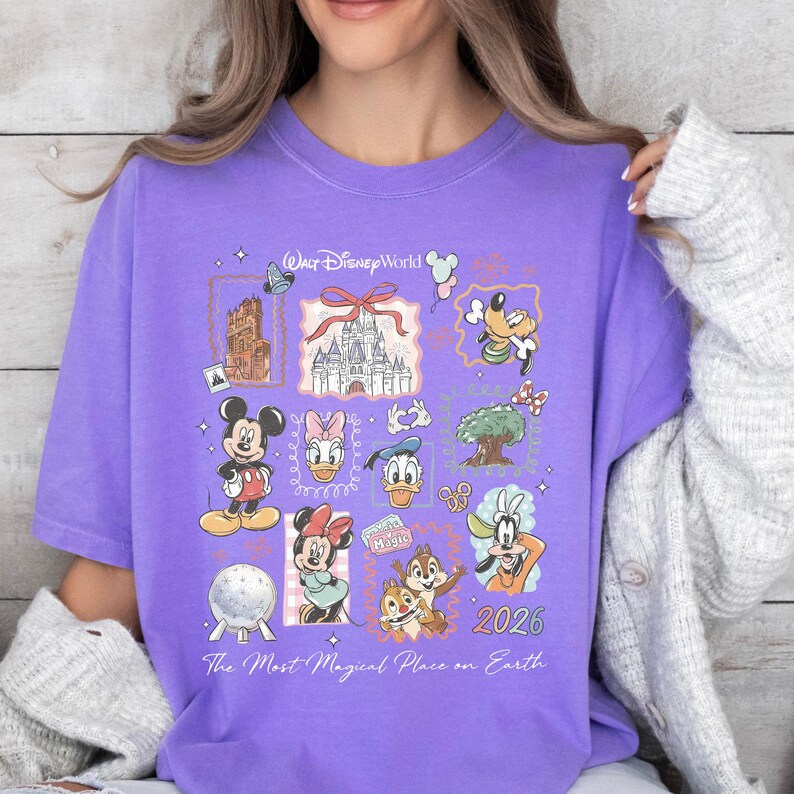 A woman wearing a purple t-shirt with various Disney characters and a castle graphic, along with the text "The Most Magical Place on Earth" and "2026".