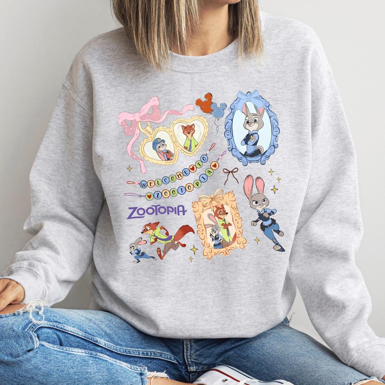 A gray sweatshirt with a colorful graphic design featuring various cartoon animal characters, including a rabbit, fox, and dog, along with a mirror and a heart.
