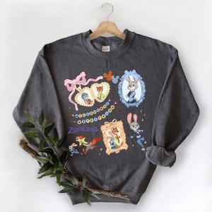 A gray sweatshirt with a colorful graphic design featuring cartoon characters and various decorative elements.