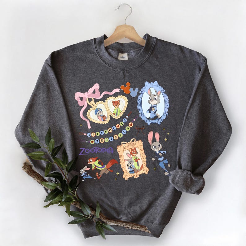 A gray sweatshirt with a colorful graphic design featuring cartoon characters and various decorative elements.