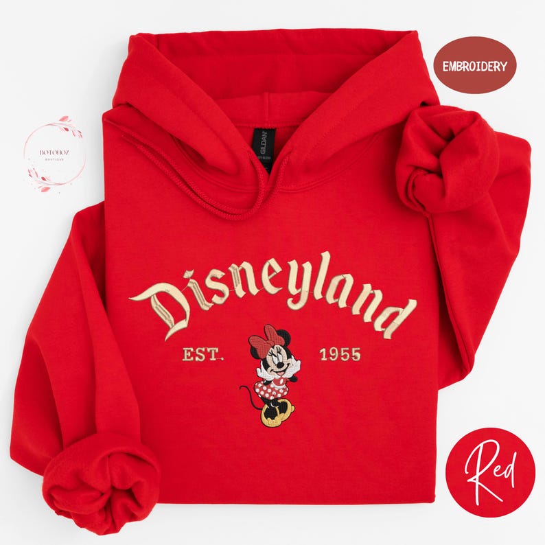 A red hoodie with the text "Disneyland" and a Minnie Mouse embroidered on it, along with the text "EST. 1955" below the Minnie Mouse.