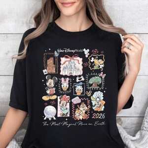 A woman wearing a black t-shirt with a collage of Disney characters and landmarks printed on it.