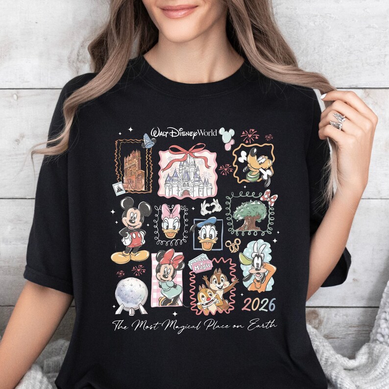 A woman wearing a black t-shirt with a collage of Disney characters and landmarks printed on it.