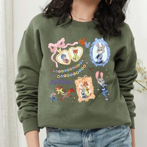 A woman wearing a green sweatshirt with various cartoon animal characters and a heart-shaped bow on it.