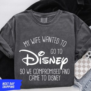 A gray t-shirt with white text that says "My wife wanted to go to Disney so we compromised and came to Disney"