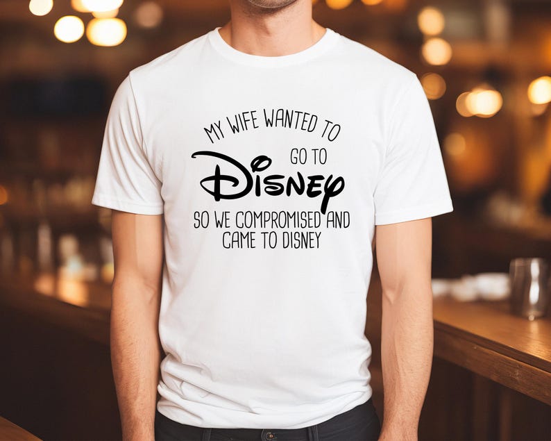 A man wearing a white t-shirt with a humorous text printed on it.