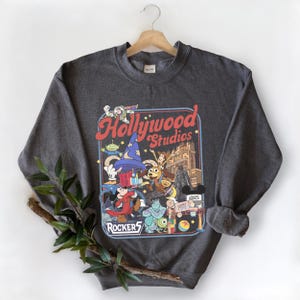 A gray sweatshirt with a graphic design featuring characters from the Disney Pixar film Toy Story, including characters like Woody, Buzz Lightyear, and a robot.