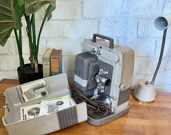 Videoproiettore Keystone K-100 per pellicole da 8 mm, modello vintage anni '50, con custodia e manuale, perfettamente funzionante.