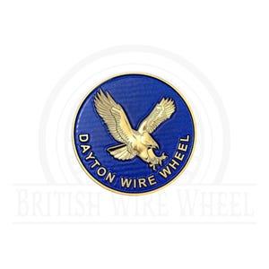 May include: A gold eagle with outstretched wings on a blue circle with the text "Dayton Wire Wheel" around the edge.