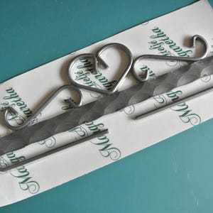 Percha vintage sueca de metal gris resistente de los años 70 con decoración de corazón para colgar en la pared, todavía en cartón
