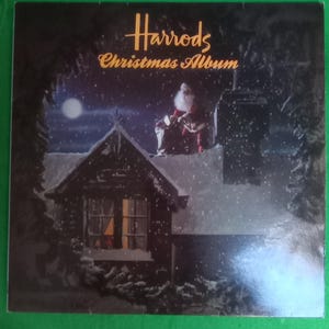 Peut inclure: Une couverture d'album vintage pour "Harrods Christmas Album" présente une scène de nuit enneigée. Le Père Noël est assis sur un toit, avec une maison et une pleine lune en arrière-plan. Le titre de l'album est en lettres dorées.