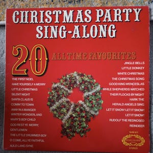 May include: A red album cover with the text "CHRISTMAS PARTY SING-ALONG" and "20 ALL TIME FAVOURITES." A wreath with red berries and silver tinsel is in the center. Song titles include "Jingle Bells" and "Rudolf the Rednosed Reindeer."