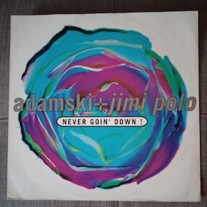 May include: Album cover featuring a vibrant, abstract floral design in shades of teal, purple, and pink. The text "adamski + jimi polo" is in a silver font above the text "NEVER GOIN' DOWN!" in a white box.