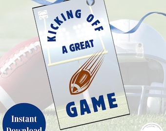 May include: A tag with the words "KICKING OFF A GREAT GAME" in blue, with a football graphic. A blue ribbon is attached to the tag. The words "Instant Download" are in a blue circle. A football and helmet are in the background.