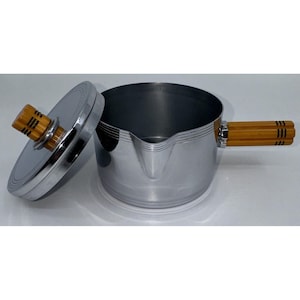 May include: A silver saucepan with a wooden handle and a matching lid. The saucepan has a spout and a decorative band around the top.