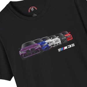 May include: Black t-shirt featuring a graphic of five BMW M3 cars in various colors, angled from front to back. The cars are purple, blue, white, dark green, and red. The text "M3" is below the cars.