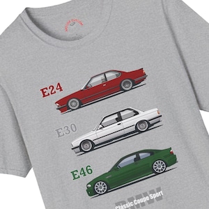 May include: A grey t-shirt displaying illustrations of three classic BMW coupe cars: a red E24, a white E30, and a green E46. The text "BMW Classic Coupe Sport" is printed at the bottom.
