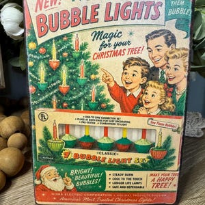 May include: Vintage NOMA Bubble Lights box with a retro design. The box features a family admiring a Christmas tree with bubble lights. Text includes "New! Bubble Lights" and "Magic for your Christmas Tree!"