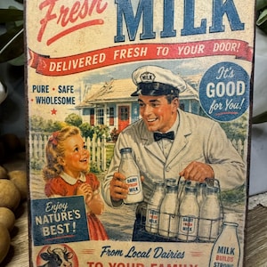 May include: Vintage-style sign with the words "Fresh Milk" in red and blue. The sign depicts a milkman delivering milk bottles to a young girl. Text includes "Delivered Fresh to Your Door!" and "From Local Dairies to Your Family."