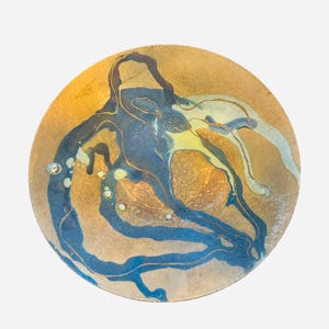 May include: A round ceramic plate with a textured, golden-brown base. Flowing blue and white abstract patterns with yellow accents create a unique design. Small, raised, clear glass-like bubbles are scattered across the surface. A decorative piece.