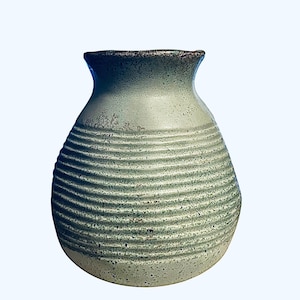 May include: A handcrafted, light green ceramic vase with horizontal ribbed detailing. The vase has a rounded body and a slightly flared neck. The rim is a darker shade of green. The vase is suitable for displaying flowers or as a decorative accent.