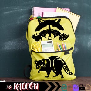 Pu&ograve; includere: Uno zaino giallo con una silhouette nera di un procione che spunta dalla tasca superiore. Lo zaino ha una tasca con cerniera sul davanti e una calcolatrice e matite nella tasca superiore. Il testo "30 RACCOON" &egrave; in basso nell'immagine.