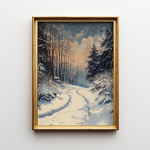 Puede incluir: Pintura enmarcada de un paisaje invernal. La obra representa un camino cubierto de nieve que serpentea a través de un bosque de árboles desnudos y perennes. El cielo es azul suave con toques de naranja y caen copos de nieve.