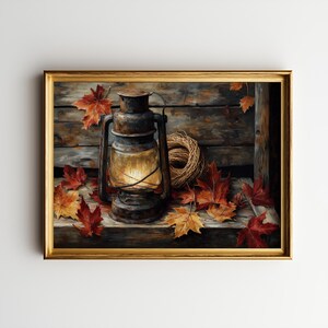 May include: A framed painting depicts a rustic scene with a vintage lantern, a coiled rope, and autumn leaves. The lantern, with a warm glow, sits on a wooden surface, surrounded by red and yellow leaves. The artwork is framed in gold.