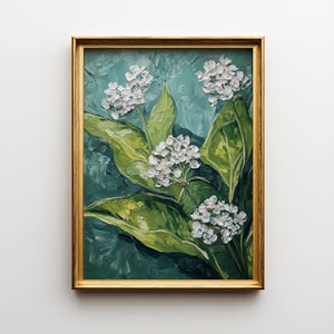 May include: A framed oil painting featuring white flowers and large green leaves against a teal background. The artwork is enclosed in a gold-colored frame, creating a classic and elegant aesthetic. The painting's textured brushstrokes add depth.