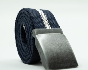 May include: A navy blue canvas belt with a white stripe and a silver-colored metal buckle. The belt is rolled up, showcasing the woven texture and design. A classic accessory.