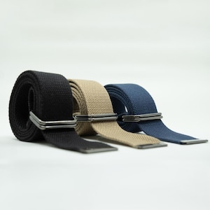 May include: Three canvas belts with metal buckles. The belts are black, beige, and blue.