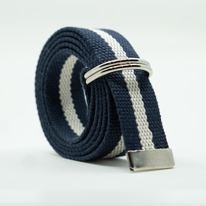 May include: A rolled navy blue and white striped belt with a silver-colored buckle and loop. The belt is made of a woven fabric and is suitable for casual wear. The belt is approximately 1.25 inches wide.