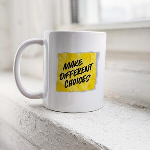 May include: White ceramic mug with a yellow sticky note that says "Make Different Choices".