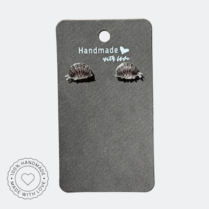 Op de afbeelding: Een paar zilverkleurige, gedetailleerde pissebed oorbellen op een grijze oorbellen displaykaart. De kaart heeft de tekst "Handmade with love" en een hartsymbool. Een ronde sticker onderaan luidt "100% Handmade with love."