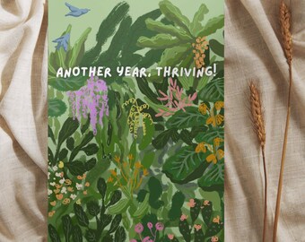 Puede incluir: Una tarjeta verde con una ilustración colorida de una escena de la jungla y el texto "Another year, thriving!"