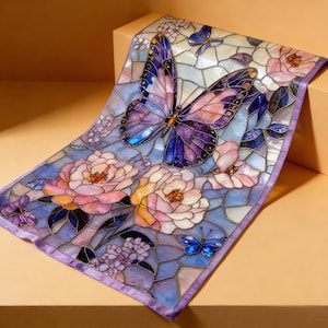 以下が含まれることがあります： 大きな紫色の蝶とピンクの花が描かれた、ステンドグラスのデザインの装飾スカーフ。 スカーフは水色の背景とラベンダー色の縁取りが施されています。 デザインは複雑で詳細で、モザイクのような外観です。