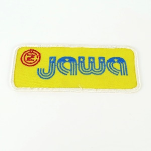 May include: Yellow rectangular patch with the word "JAWA" in blue, stylized font. A red circle with a "Z" inside is in the upper left corner. The patch has a white border.