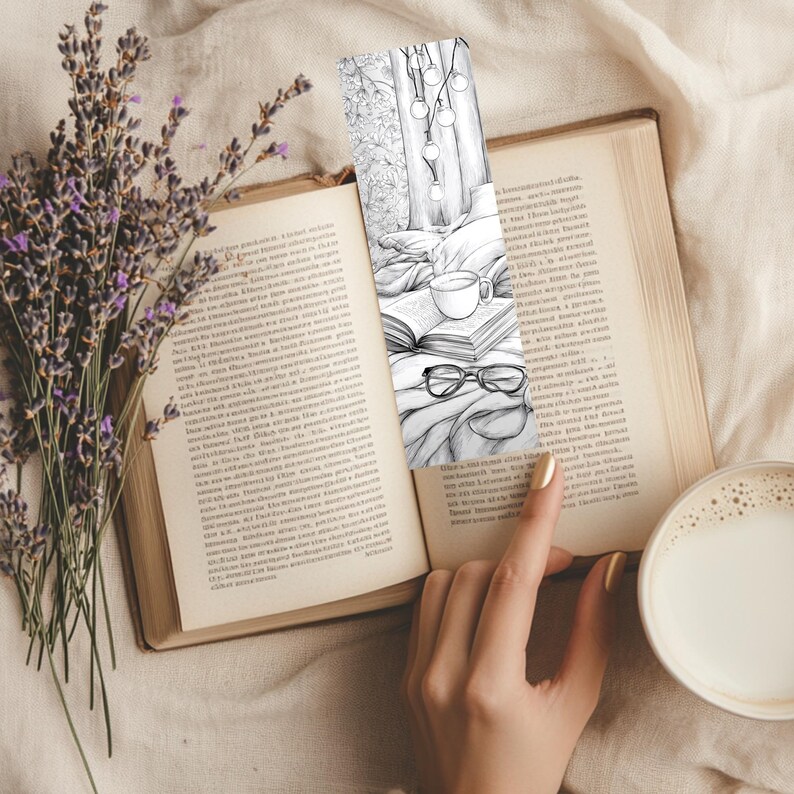 May include: A bookmark featuring a cozy reading scene with a cup of coffee, glasses, and a book. The bookmark is placed in an open book, next to a bouquet of lavender and a cup of coffee with milk.