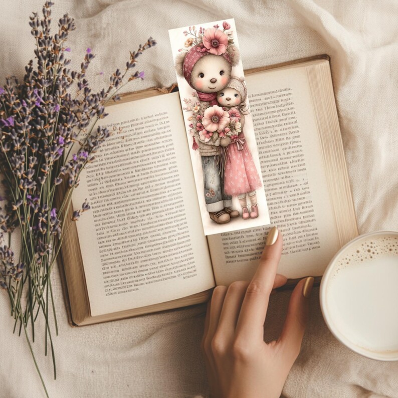 May include: A decorative bookmark featuring a bear and a child, both wearing hats and holding flowers. The bookmark is placed in an open book, with a cup of coffee and lavender sprigs in the background.