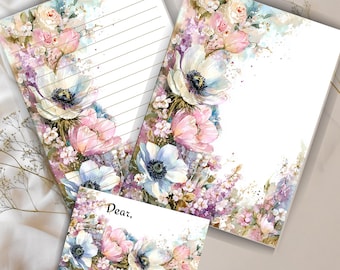 May include: Stationery set featuring watercolor floral designs. The set includes lined paper, a blank sheet, and a card. The flowers are in shades of white, pink, and blue, with green leaves and purple accents. The card has the word "Dear," printed on it.