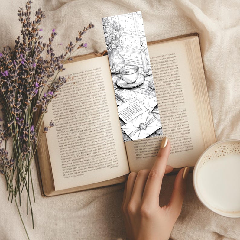 May include: A black and white bookmark featuring a cozy scene with a teacup, candle, and letters, placed in an open book. A sprig of lavender and a cup of coffee are also visible.