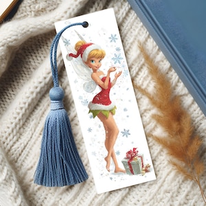 Peut inclure: Un marque-page rectangulaire en papier illustr&eacute; d'une f&eacute;e blonde v&ecirc;tue d'une tenue de style P&egrave;re No&euml;l rouge et blanche avec des bordures vertes. La f&eacute;e tient une baguette parmi des flocons bleus. Un cordon bleu avec un pompon est attach&eacute;.