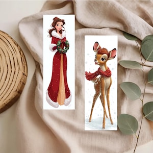 Peut inclure: Deux marque-pages rectangulaires illustr&eacute;s. L'un repr&eacute;sente une femme aux cheveux bruns v&ecirc;tue d'un long manteau rouge &agrave; bordure de fourrure blanche, tenant une couronne verte. L'autre montre un faon brun tachet&eacute; portant une &eacute;charpe rouge.