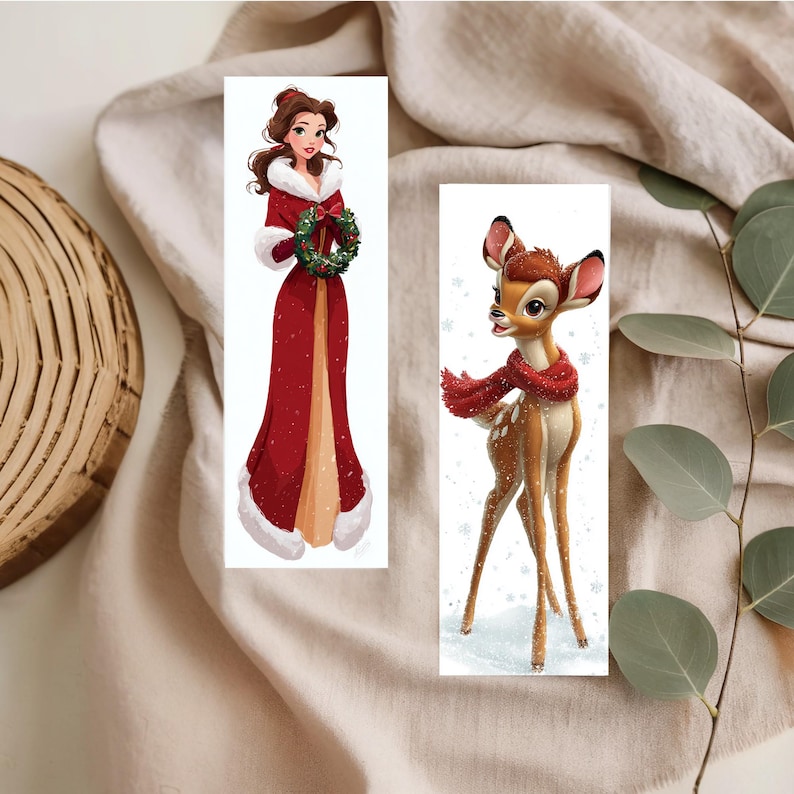 Peut inclure: Deux marque-pages rectangulaires illustr&eacute;s. L'un repr&eacute;sente une femme aux cheveux bruns v&ecirc;tue d'un long manteau rouge &agrave; bordure de fourrure blanche, tenant une couronne verte. L'autre montre un faon brun tachet&eacute; portant une &eacute;charpe rouge.