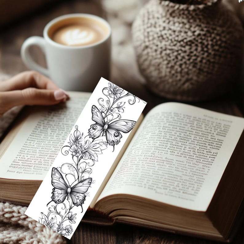Op de afbeelding: Een rechthoekige boekenlegger met een gedetailleerde zwart-wit lijntekening van twee vlinders omringd door ingewikkelde bloemenranken en bladeren. Het ontwerp is gedrukt op een witte achtergrond met duidelijke, scherpe inktlijnen.