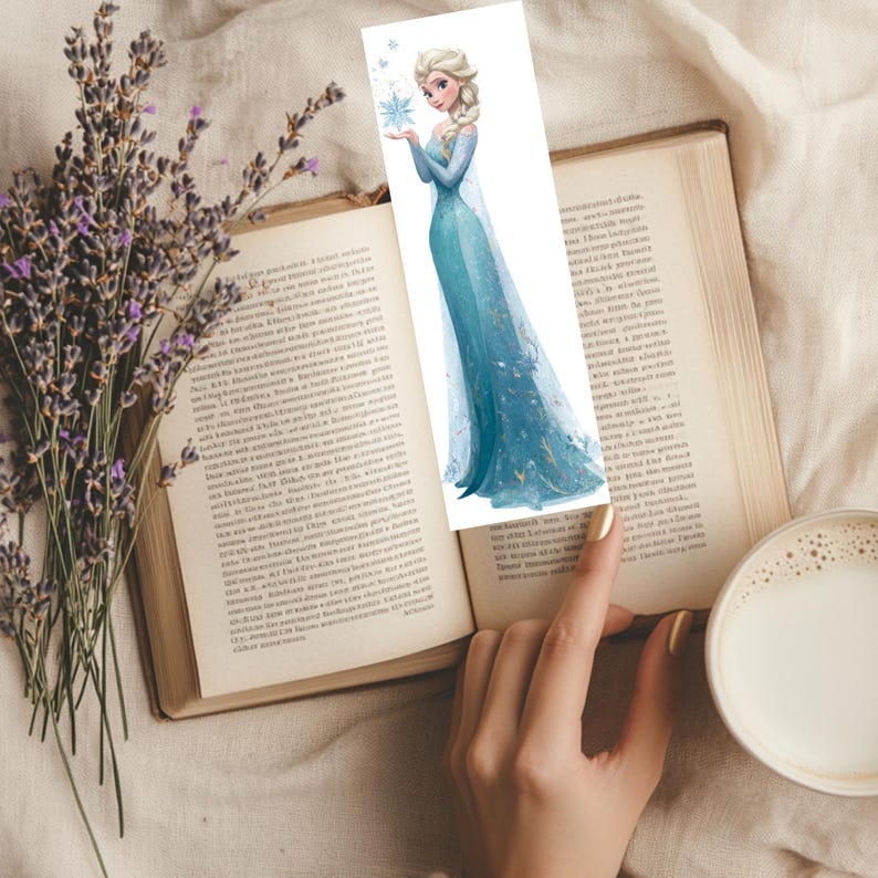 Peut inclure: Un marque-page en papier rectangulaire pr&eacute;sentant une illustration imprim&eacute;e d'un personnage blond avec une coiffure tress&eacute;e, portant une longue robe bleue scintillante et tenant un flocon de neige bleu sur un fond blanc avec des flocons.