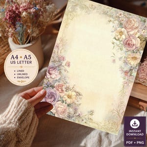 May include: A rectangular stationery sheet with a cream-colored background, featuring ornate floral illustrations of roses and wildflowers in soft pastel shades of pink, purple, and yellow along the edges, with a decorative border and text.