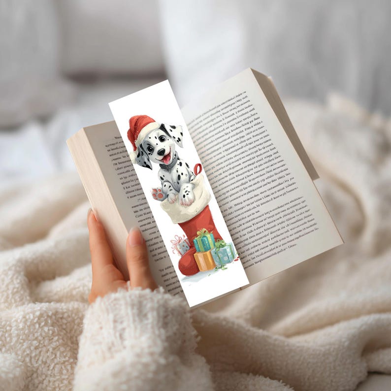 Peut inclure: Un marque-page rectangulaire pr&eacute;sentant une illustration &agrave; l'aquarelle d'un chiot dalmatien portant un bonnet de P&egrave;re No&euml;l rouge, sortant d'une chaussette de No&euml;l rouge. La chaussette est entour&eacute;e de petits cadeaux emball&eacute;s color&eacute;s.