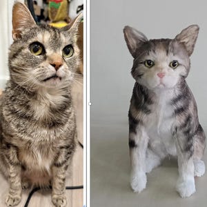 May include: A tabby cat with brown and gray stripes, sitting upright with a curious expression. The cat has yellow-green eyes and a pink nose. The cat's fur is detailed, and the overall appearance is lifelike.