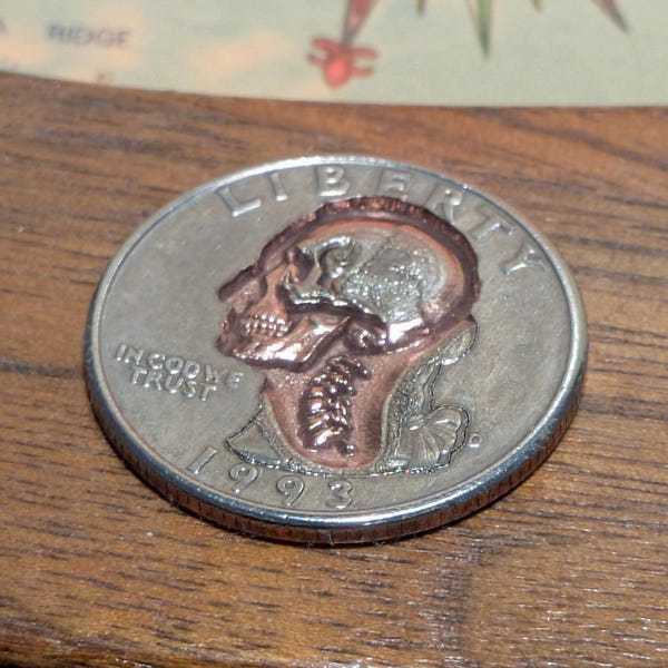 Moneda de veinticinco centavos desfigurada: Calavera grabada con láser